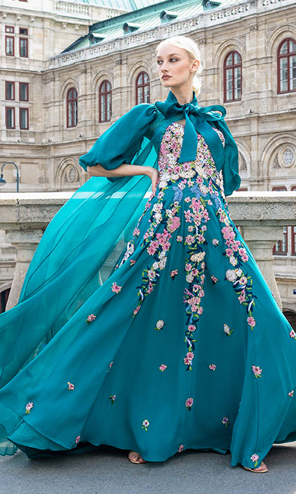Woman in a turquoise floral ball gown and opera jacket