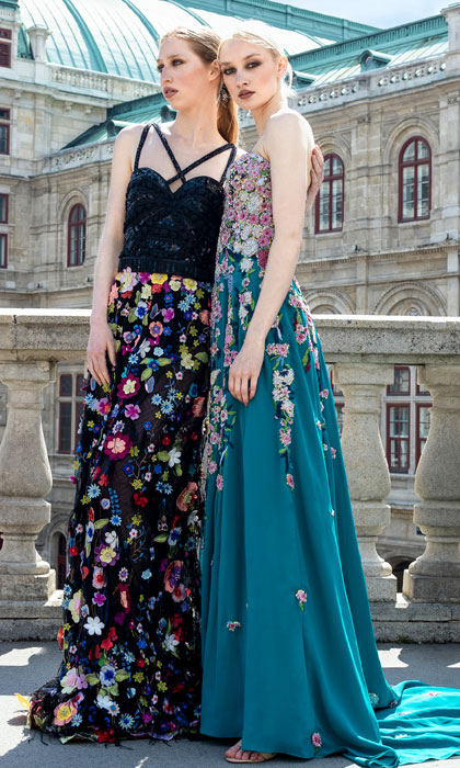 Two women in a black and floral gown, and turquoise floral gown