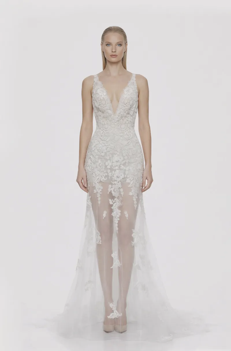 Front view of a woman in an Off-white tulle v-neck mermaid gown with see-through skirt embellished with cascading corded lace 7, image 1