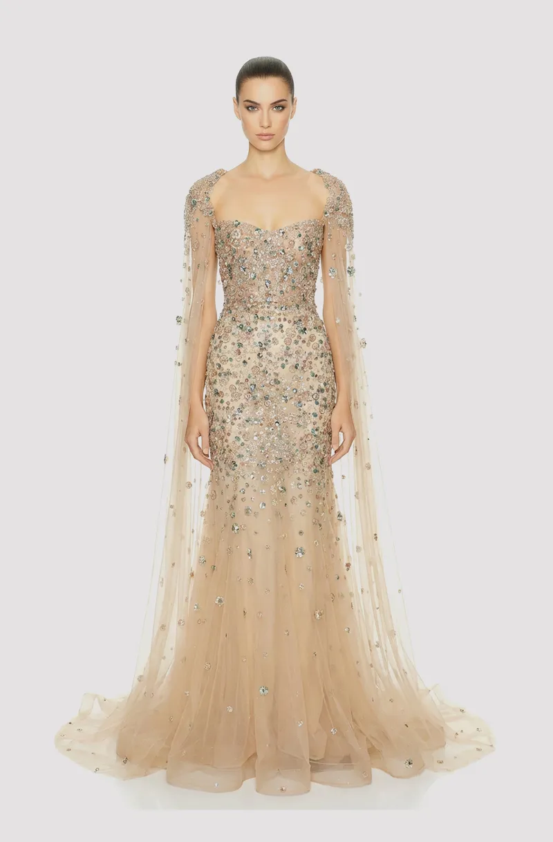 Front view of a woman in a Nude tulle hand-beaded couture mermaid gown with corseted bodice and matching detachable beaded cape 12, image 1
