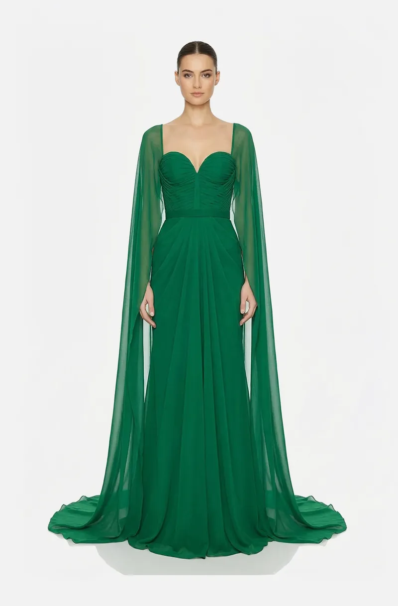 Front view of a woman in an Emerald green silk chiffon draped gown and sheer attached cape sleeves 5, image 1